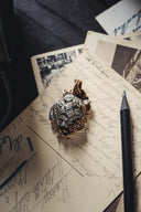 a ring sitting on top of a piece of paper next to a pen