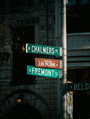 a pole with street signs on it in front of a building