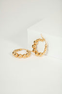a pair of gold hoop earrings on a white surface