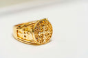 a close up of a gold ring on a white surface