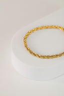 a gold bracelet on a white surface