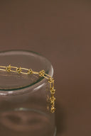 a close up of a gold chain on a glass container