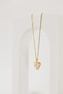 a gold necklace with a heart on it