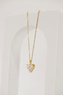 a gold necklace with a heart on it