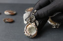 a close up of a person holding a piece of jewelry