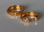 two gold rings sitting on top of a table