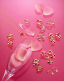 A pink table topped with lots of jewelry