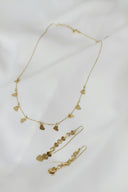 A necklace and earring set on a white sheet