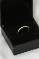 A black box with a gold ring inside of it