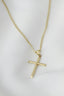 A gold cross necklace on a mannequin