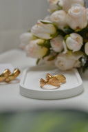 A bouquet of white roses and two gold rings