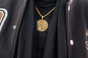 A man wearing a black jacket and a gold necklace