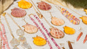 Seashell jewelry pieces are arranged on a white surface.
