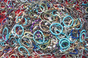 Bracelets of various colors and styles are piled together