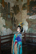 Woman in traditional chinese attire with elaborate headdress.