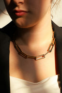 A woman wears a chunky gold chain necklace