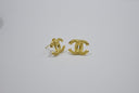 Gold interlocking cc logo earrings on white background
