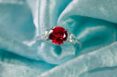 A ruby and diamond ring on blue silk