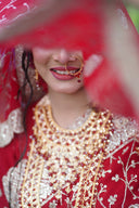 Bride in red attire with traditional indian jewelry.
