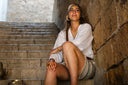 Young woman sits on ancient stone steps