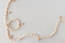 Beaded garland with small golden bells on white