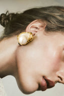Elegant pearl and gold earring on woman's ear