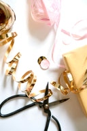 Gold ribbon, scissors, and gift wrapping supplies.