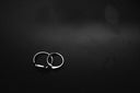 Two silver rings on a dark background