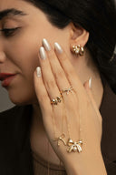 Woman wearing gold jewelry with pearl accents.