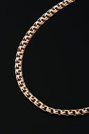 A close-up of a gold chain on black background