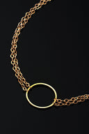 A delicate gold necklace with a circular pendant