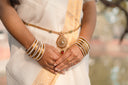 Woman wearing traditional indian jewelry and white saree