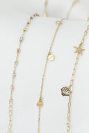 Three delicate gold necklaces with charms on white background