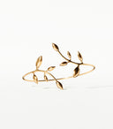 A golden leaf-shaped bracelet on a white background
