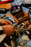 A person sorting through a collection of vintage jewelry on a blue cloth