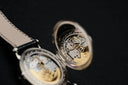 Silver-toned pocket watch with visible gold-tone gears inside open case in an everett jewelry store article on engagement rings