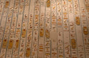 Ancient Egyptian wall with hieroglyphics in faded gold and ochre reflects powerful symbols like those in Everett jewelry store.