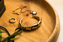 Gold-toned segmented bangle with sleek modern design showcasing elegant art gold jewelry for timeless gleam preservation
