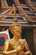 Gold gilded statue of a guardian figure with intricate detailing and ornate headdress showcasing art gold craftsmanship