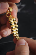 a person holding a gold necklace in their hand