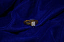 A gold ring with diamonds on blue silk
