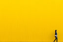 woman wearing black top standing near yellow wall