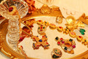 A golden ornate necklace with a central red gemstone and floral design showcasing crown jewels fine jewelry elegance