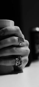 Hand with 18k gold royal jewels grips white mug, revealing hidden compartments