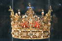 A royal golden crown displayed in a case.
