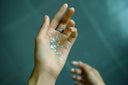 Hand holding iridescent star-shaped glitter resembling royal jewels