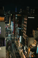 Vibrant cityscape with illuminated buildings and traffic at night.