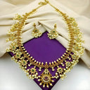 Royal jewels gold necklace with floral designs, pearls, green stones