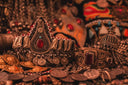 An ornate gold filigree headpiece with a central red gemstone showcasing royal art gold jewelry craftsmanship.