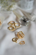 Elegant 18k gold layered rings with clear stones on white fabric